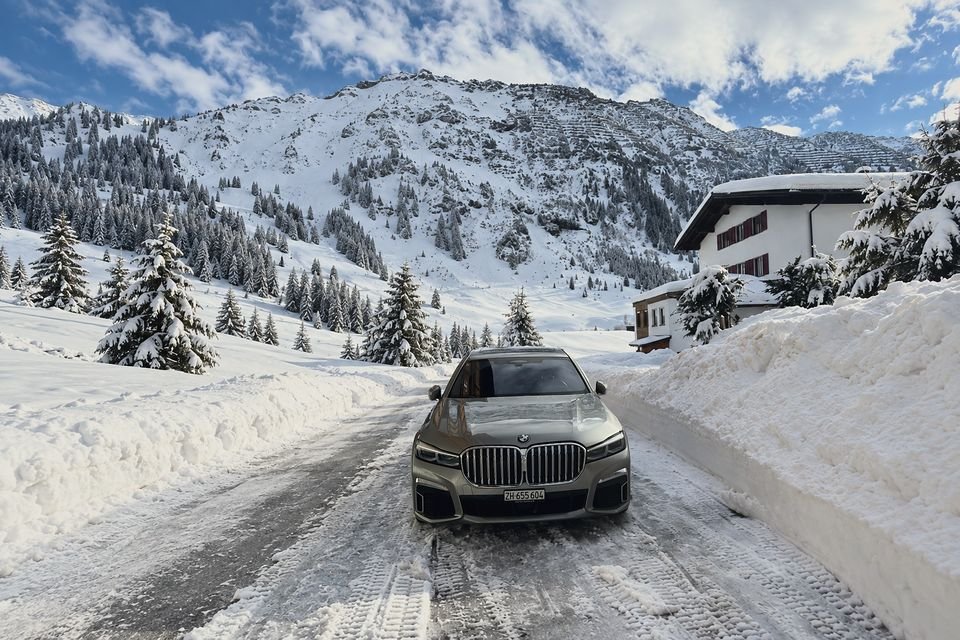 Grey BMW 7 Series on a snowy mountain village street