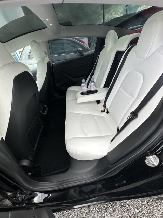 Tesla rear bench in white leather, with bottled water in the armrest