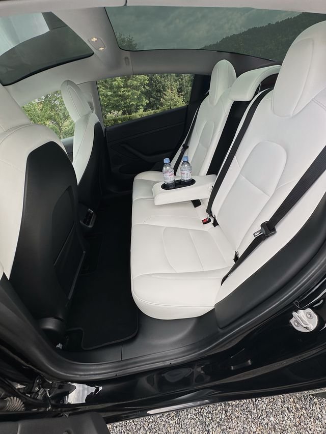 Tesla rear bench in white leather, with bottled water in the armrest