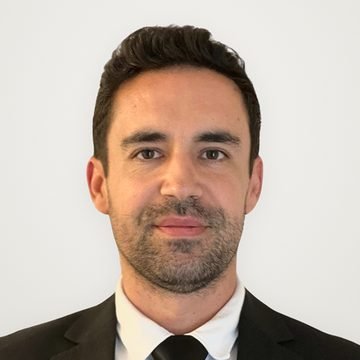 Express Transfer chauffeur with a short beard, in a black suit and tie