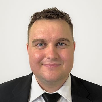 Express Transfer chauffeur smiling, in a black suit and tie