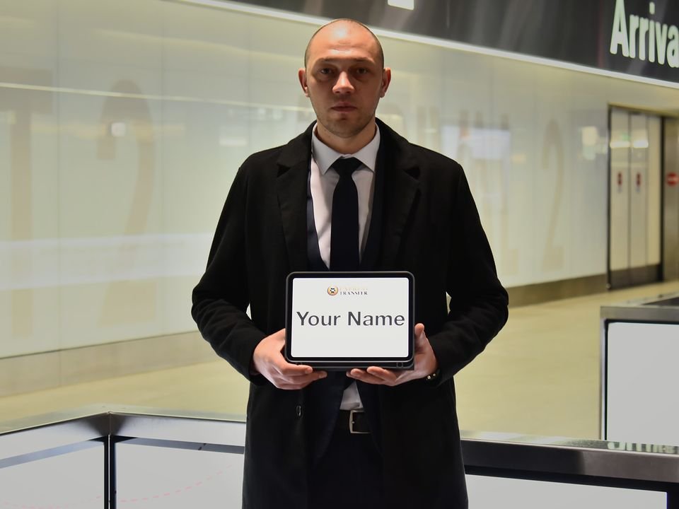 Express Transfer chauffeur holding a name tablet in the Zurich Airport arrivals hall