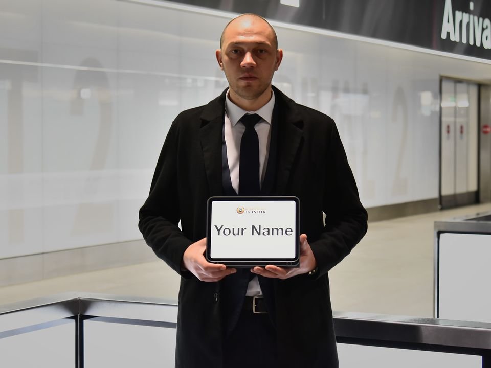 Express Transfer chauffeur holding a name tablet in the Zurich Airport arrivals hall