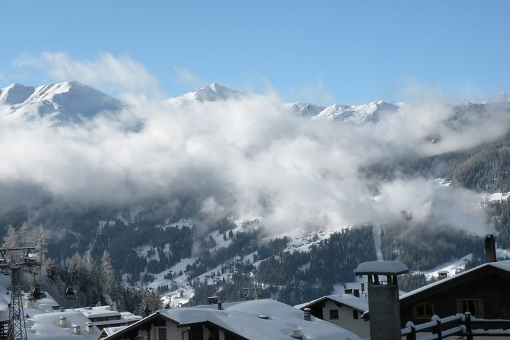 Verbier in winter: chalet roofs, clouds and snowy peaks