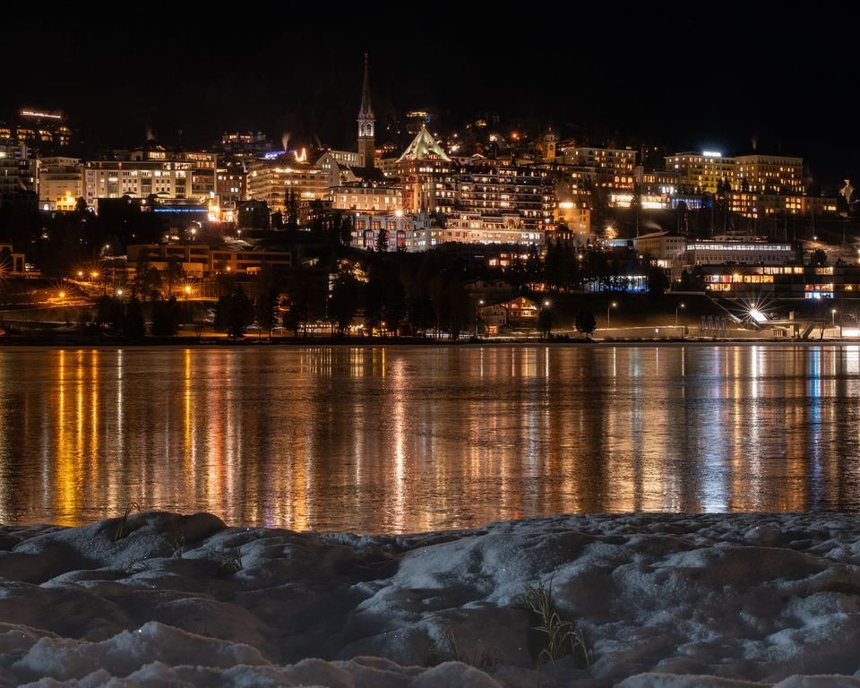 St. Moritz at night: the lights of the town reflected in the lake