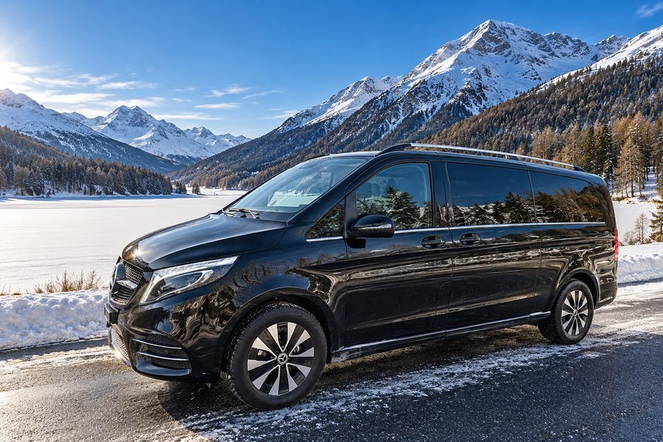 Our black Mercedes V-Class on a cleared winter road beside a frozen mountain lake
