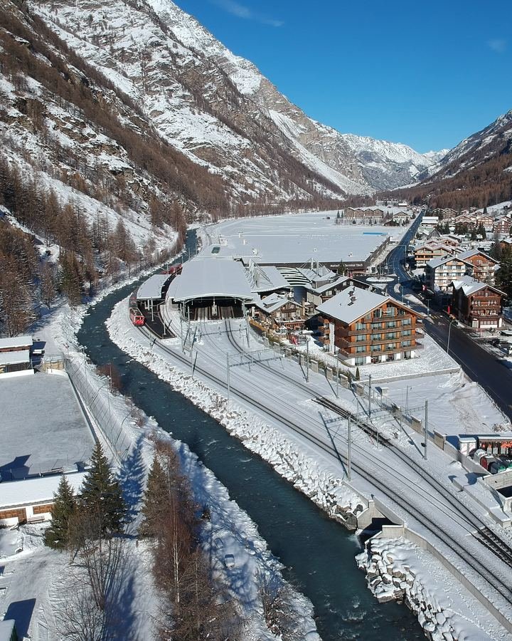 Täsch im Winter von oben: das Matterhorn Terminal, die Bahnlinie nach Zermatt und das Dorf