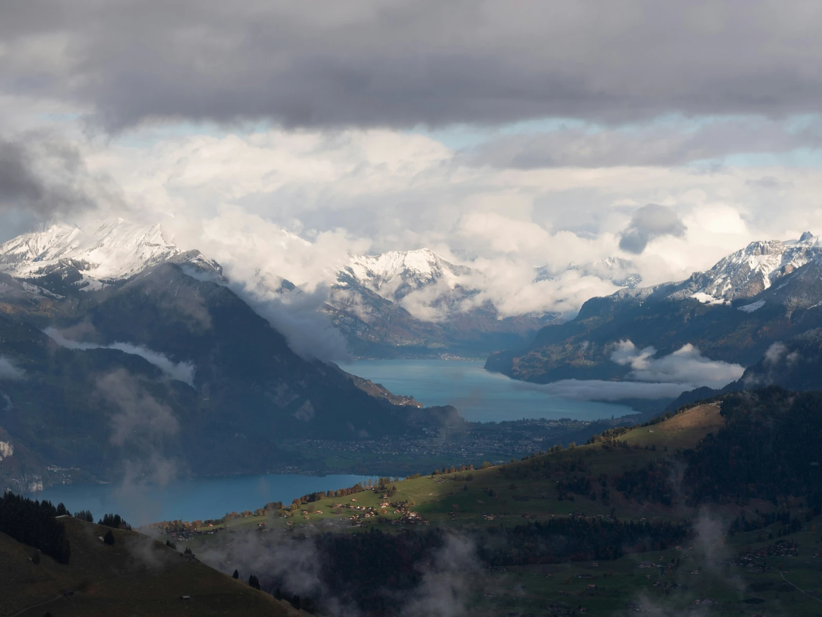 Interlaken between Lake Thun and Lake Brienz beneath cloud-covered mountains.